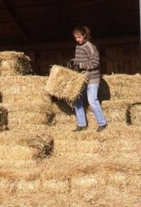 Winter shot of a girl stacking bales.